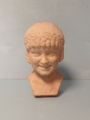 une tête d'enfant en argile posée sur une table
