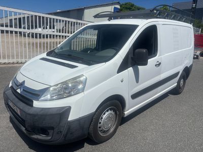La camionnette blanche est garée sur un parking près d'une clôture
