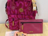 pink purse and wallet sitting on top of a table next to a pink purse