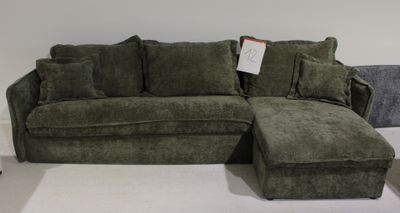 un canapé et un pouf dans une pièce aux murs blancs