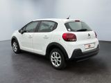 the back of a white car parked in a large room