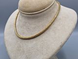 a close up of a white mannequin with a gold necklace on it