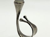 a close up of a silver ring with a white stone in it