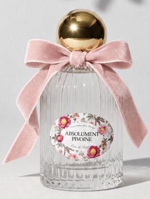 an image of a bottle of perfume with a pink bow on top