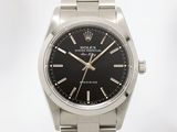 Montre Rolex avec cadran noir et boîtier noir, montée sur un bracelet en acier inoxydable
