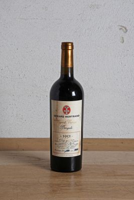 a bottle of red wine sitting on a wooden table