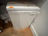 a white dishwasher sitting on top of a wooden floor
