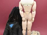 a mannequin and a teddy bear sitting next to each other