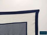 the blue and white striped blanket is folded on the bed