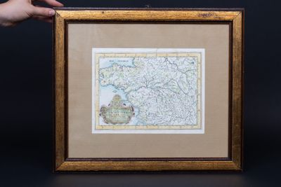 an old map of the united states in a frame with a hand holding it