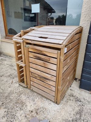 une poubelle en bois posée devant un immeuble