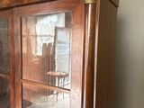 une armoire en bois avec des portes vitrées et un miroir sur la porte