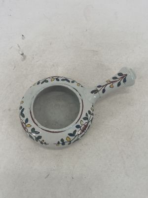 un petit vase blanc orné d'un motif floral