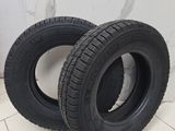 two black tires on a white tiled floor next to a wall