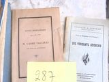 de nombreux livres anciens posés sur une table, sur laquelle se trouve une note