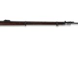 un fusil avec un canon en bois sur fond blanc