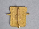 a gold pin with a pair of scissors on it