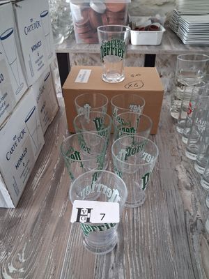 bottles and glasses on a table with boxes of beer
