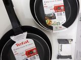 two black fry pans sitting on a white table