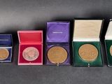 several gold medals are lined up in a row on a table