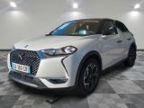 une voiture blanche garée dans une pièce au sol en damier
