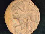 an old coin with a bird on it sitting on a black surface