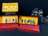 de nombreuses figurines représentant des personnes, rangées dans une boîte posée sur une table