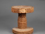 a carved table with a face on top of it