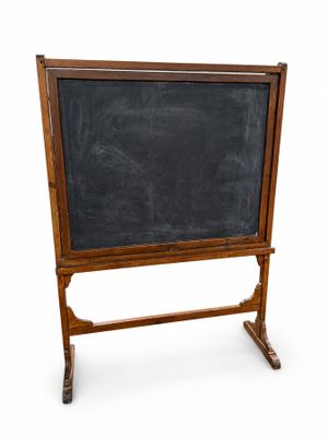 un vieux tableau noir posé sur un support en bois, sur fond blanc