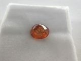 a close up of an orange stone on a white cloth
