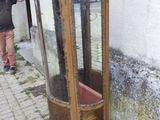 un homme debout à côté d'une grande vitrine en bois