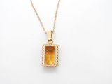 a gold pendant with a citrine stone on a gold chain