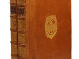 un vieux livre relié en cuir, avec un emblème doré sur la couverture