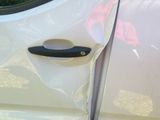 a white van with a black handle and a red sticker on the door