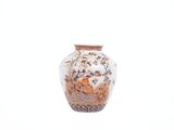 a vase with a floral design on it sitting on a table