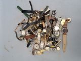 a pile of assorted watches and watches on a table
