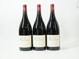trois bouteilles de vin rouge sont alignées sur une surface blanche