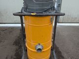 a yellow drum with a black top on a cart