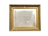 un miroir à cadre doré accroché à un mur blanc
