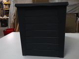 a black trash can sitting on a table in a warehouse