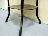 a small table with a wooden top on a cement floor
