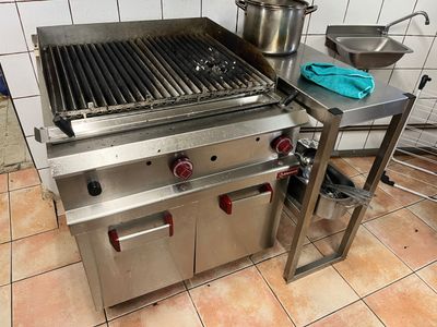 une grille en acier inoxydable surmontée d'une casserole
