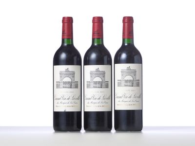three bottles of red wine sitting on top of a table