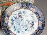 three plates with birds and flowers on them sitting next to each other