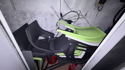 une pile de chaises et une table dans un coin de la pièce