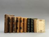 plusieurs vieux livres sont alignés sur une surface grise