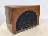 une vieille radio en bois posée sur une table blanche