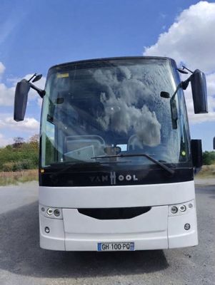 a white bus that is parked on the side of the road