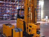 a forklift in a large warehouse with pallets on the floor