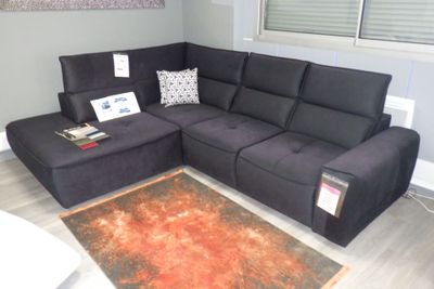 un canapé modulable noir dans un salon avec un tapis rouge